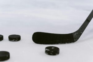 Detailed view of a hockey stick and pucks on ice, perfect for sports visuals.